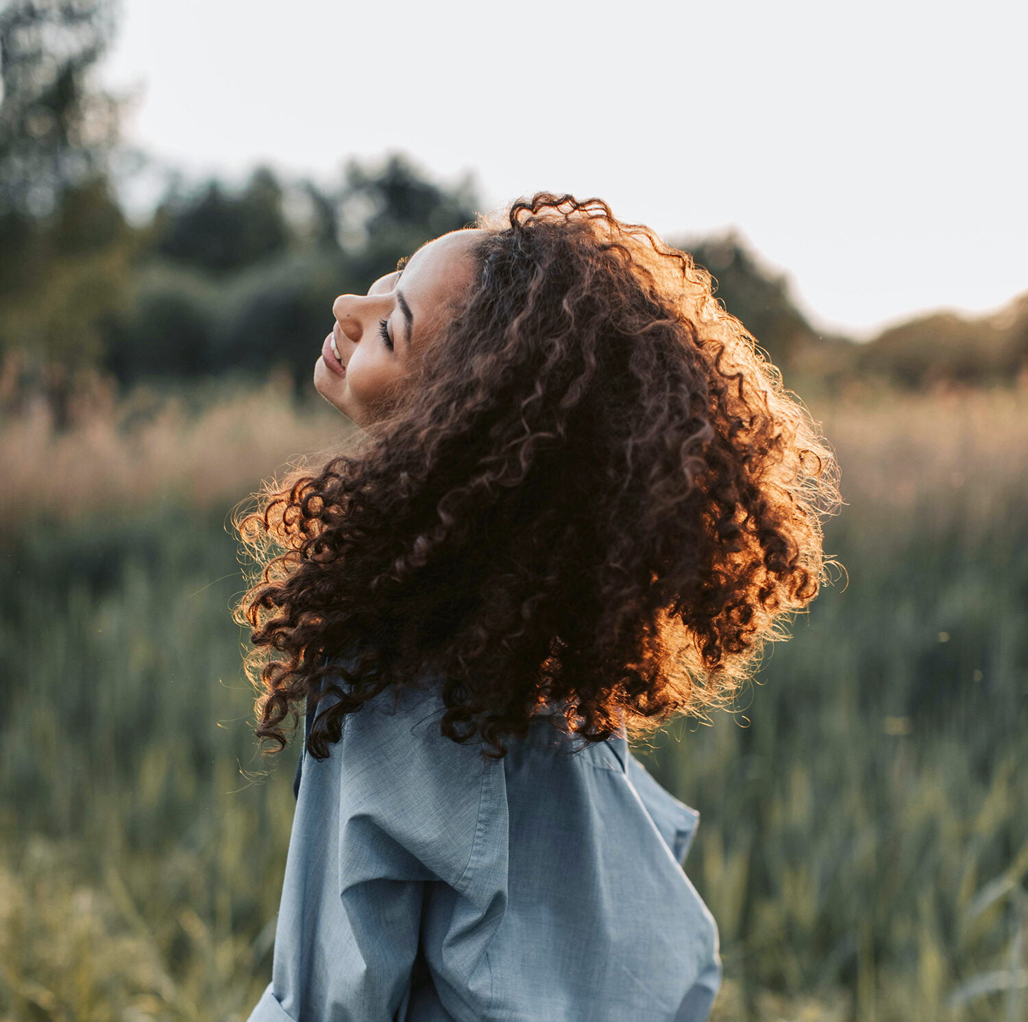 Foto einer Frau bei Abenddämmerung auf einer Wiese