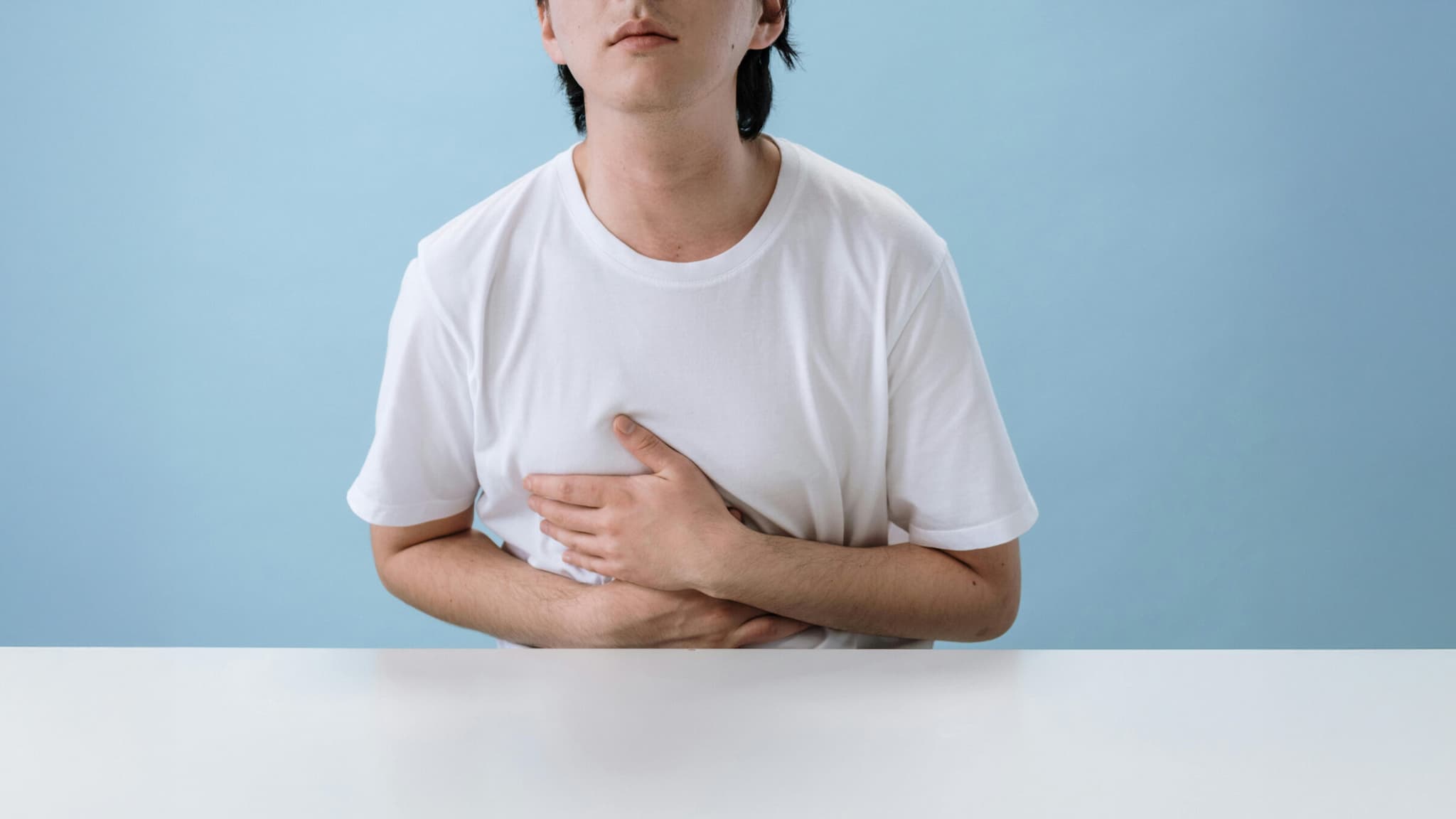 Foto eines jungen Mannes in Schmerzpose